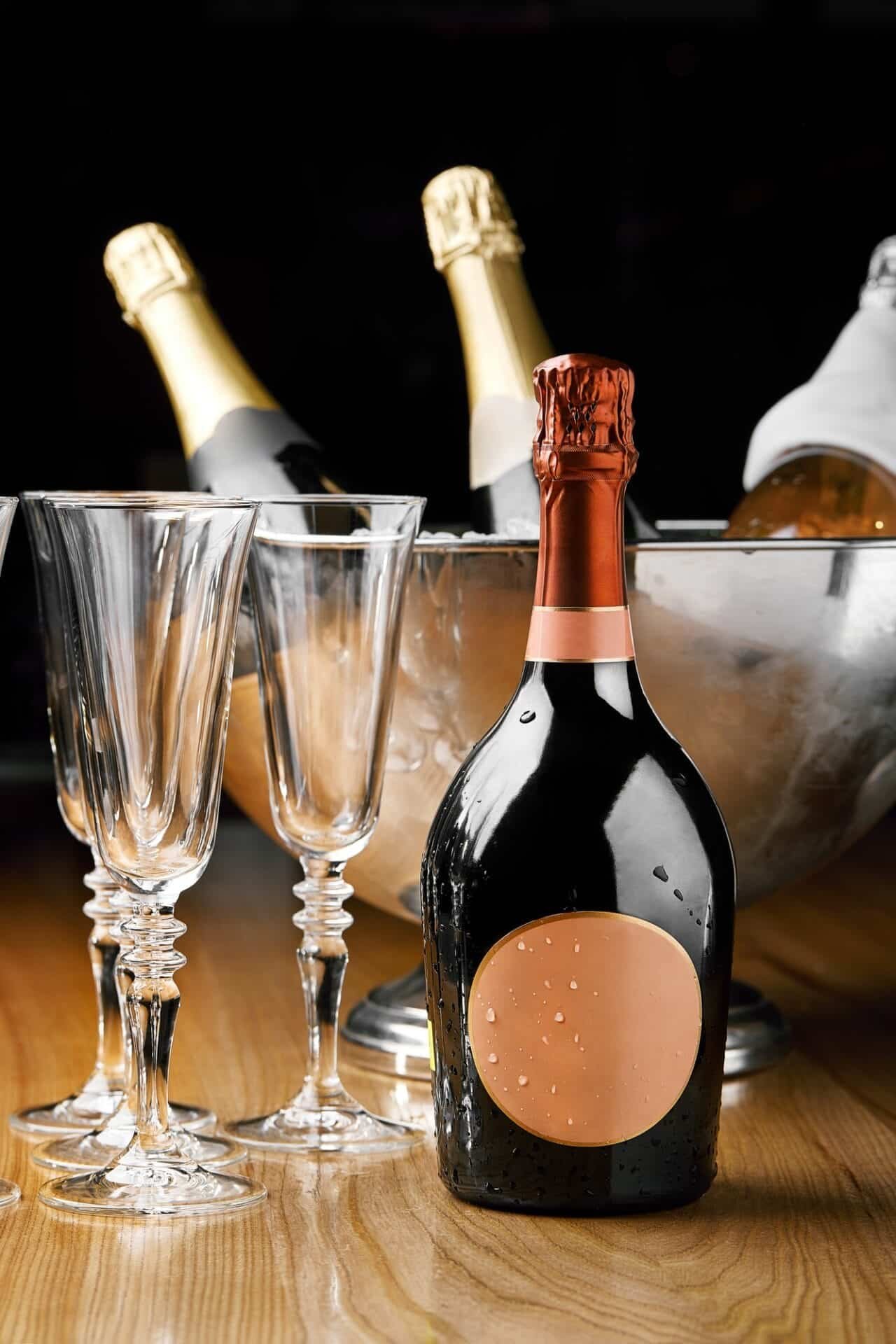 Bottle of champagne and glasses for champagne, on the background of a cooler with ice and champagne