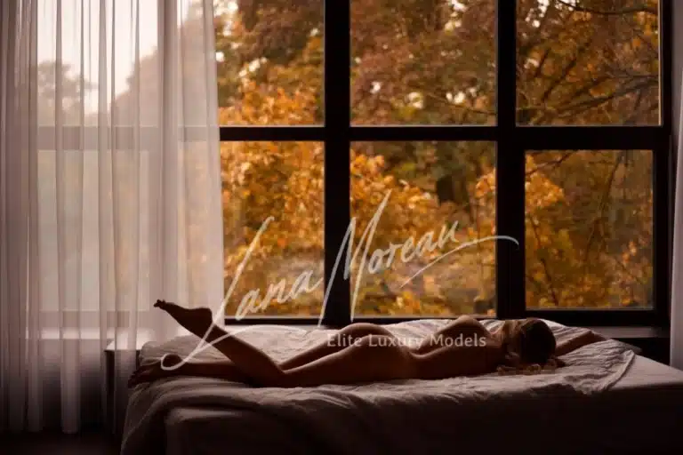 Nude blonde escort Zurich relaxing on hotel bed with view