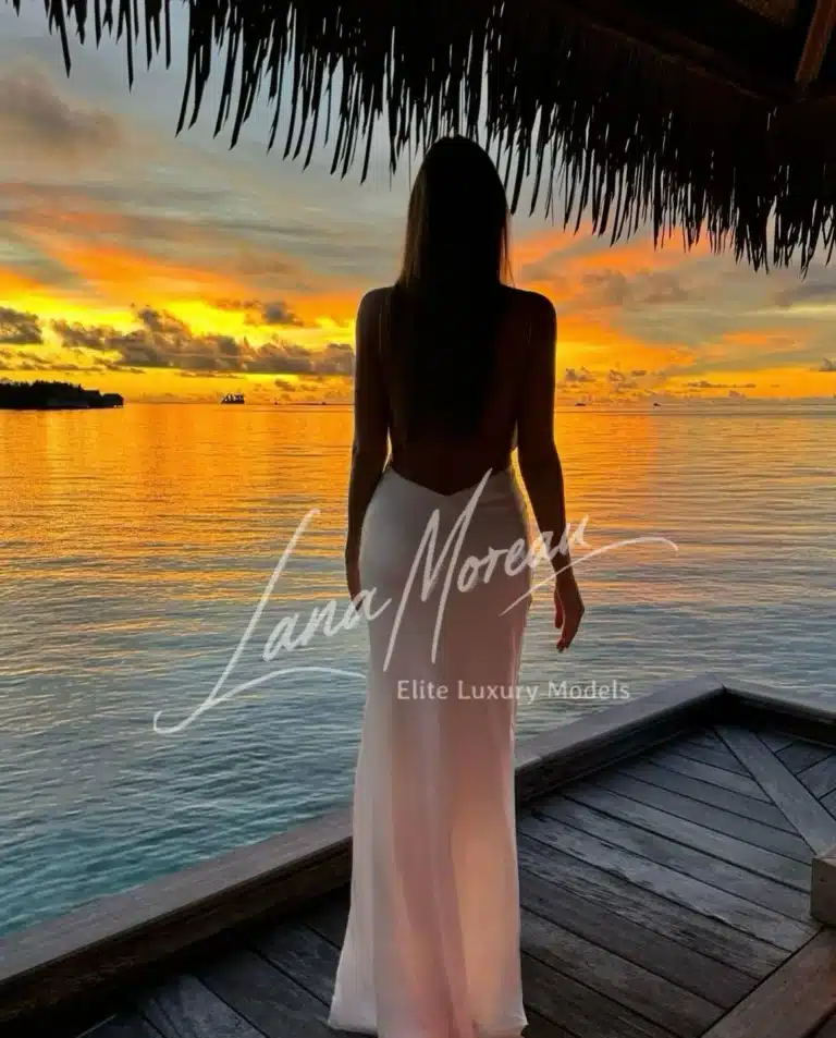 Back view of Alena at sunset in a flowing white dress.