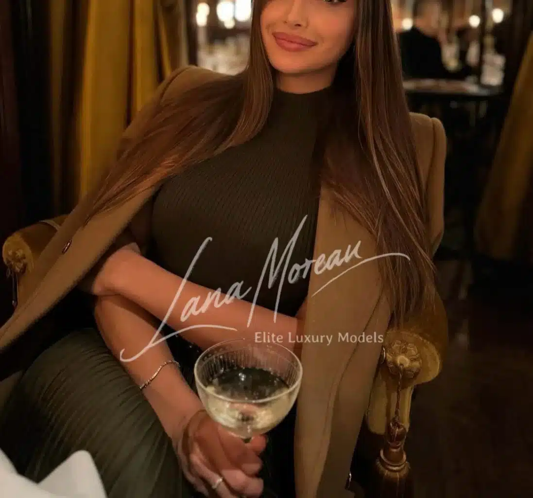 Alena with wine glass, radiant in chic evening style.