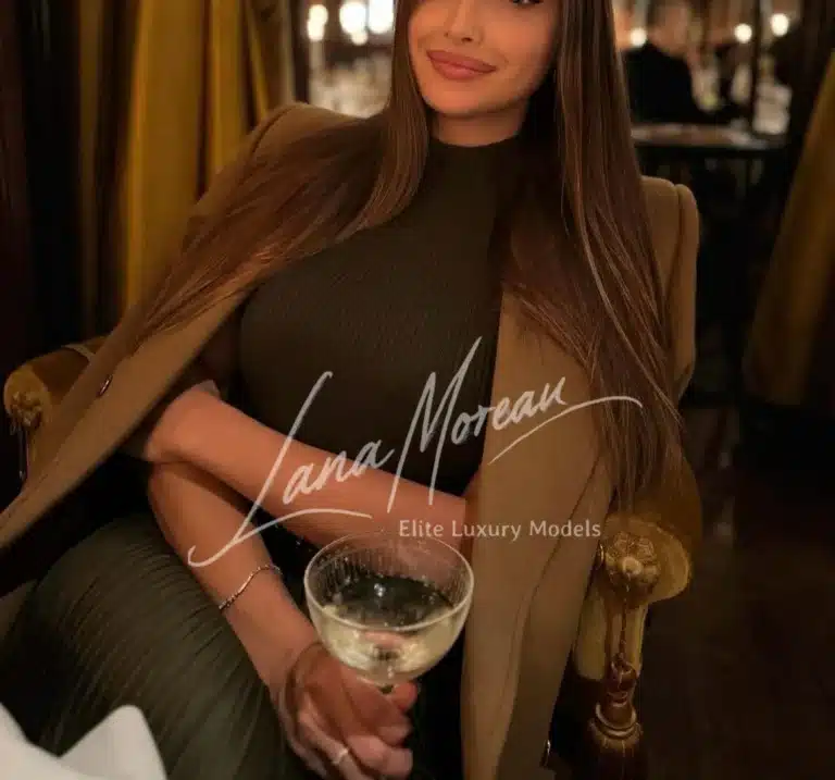 Alena with wine glass, radiant in chic evening style.